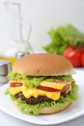 Photo of Tasty cheeseburger on white table, closeup. Space for text