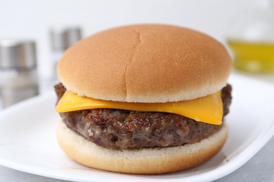 Photo of Cheeseburger with tasty patty on white table, closeup