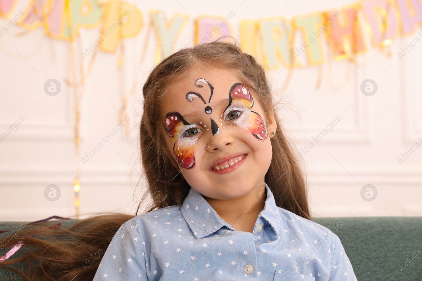 Cute girl with butterfly face painting indoors Photo of Cute girl with butterfly face painting indoors