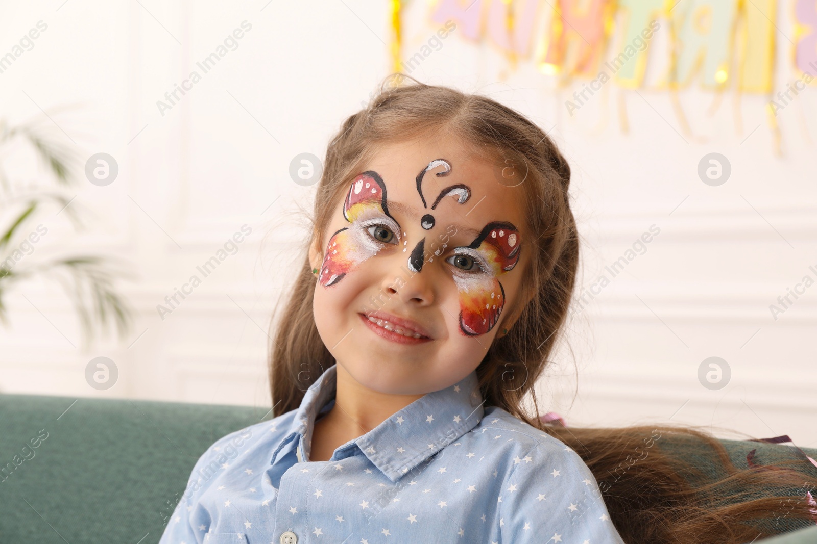 Cute girl with butterfly face painting indoors Photo of Cute girl with butterfly face painting indoors