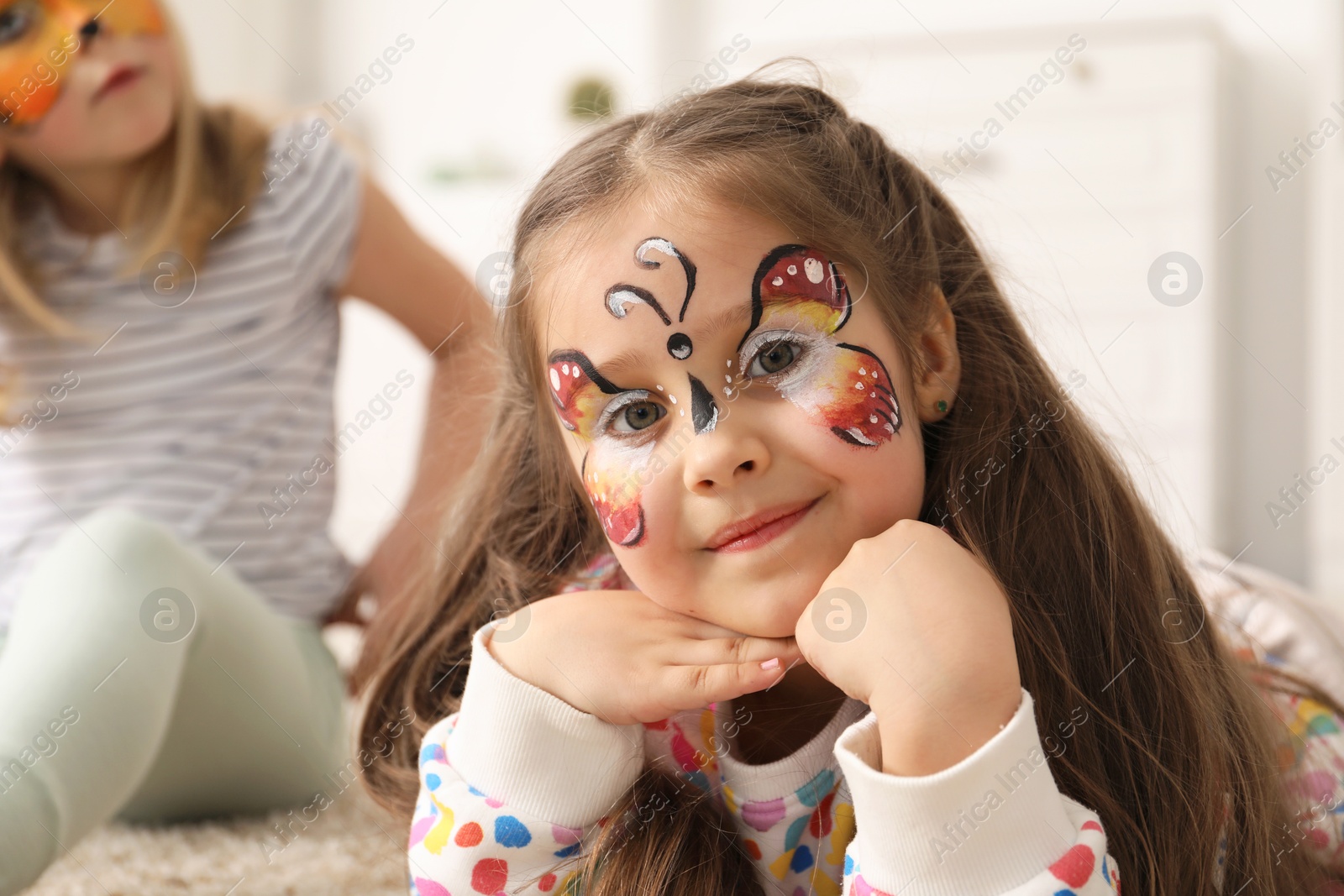 Cute girls with colorful face paintings indoors, selective focus Photo of Cute girls with colorful face paintings indoors, selective focus