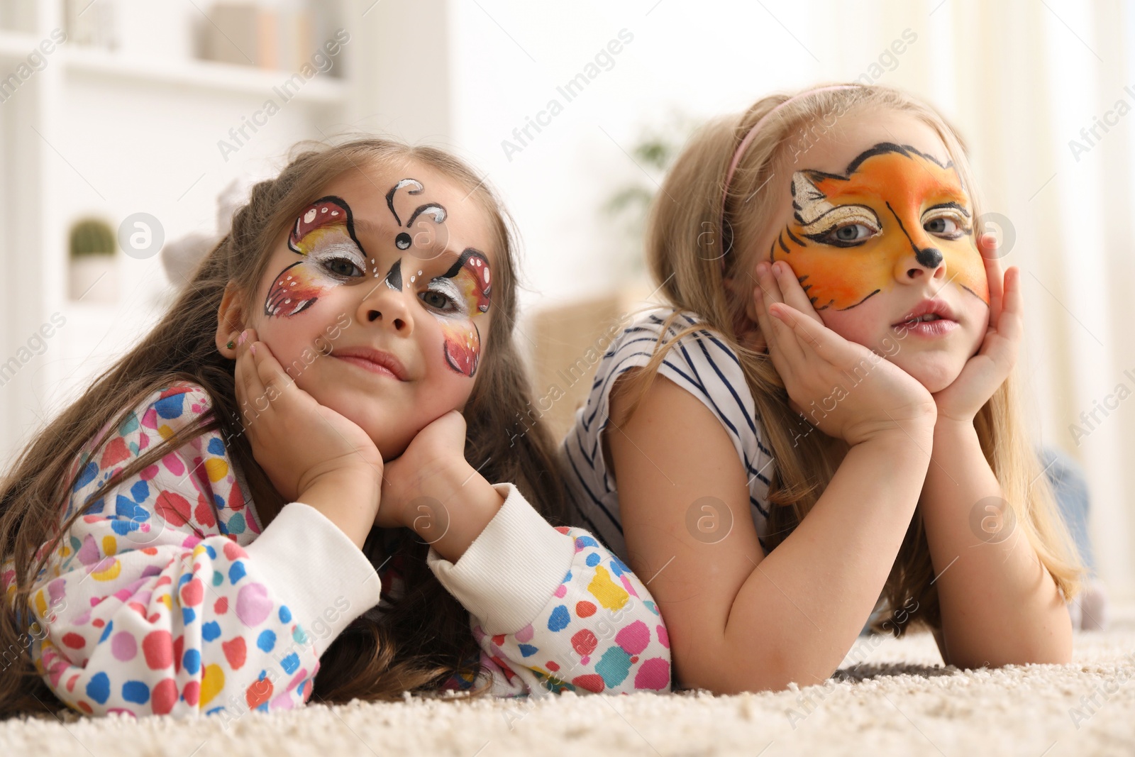 Cute girls with colorful face paintings indoors Photo of Cute girls with colorful face paintings indoors