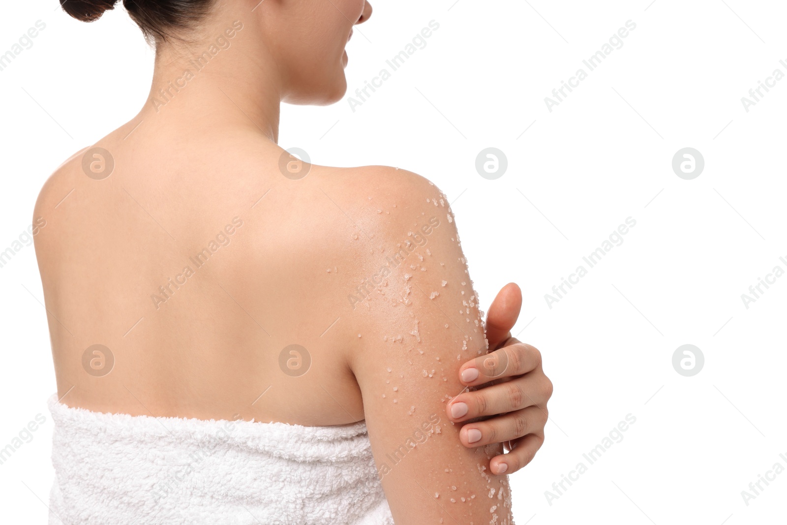 Woman applying body scrub onto her arm against white background, back view Photo of Woman applying body scrub onto her arm against white background, back view