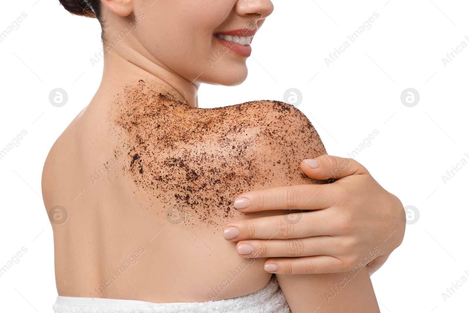 Smiling woman applying body scrub onto her shoulder against white background Photo of Smiling woman applying body scrub onto her shoulder against white background