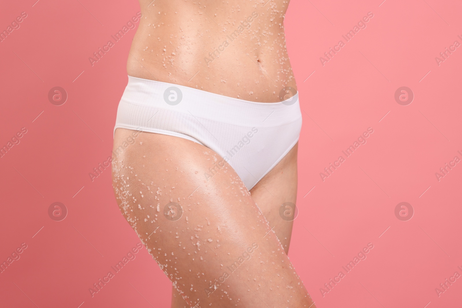 Woman with body scrub on her skin against pink background, closeup Photo of Woman with body scrub on her skin against pink background, closeup