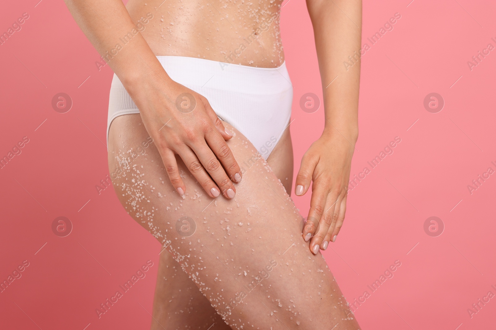 Photo of Woman with body scrub on her skin against pink background, closeup