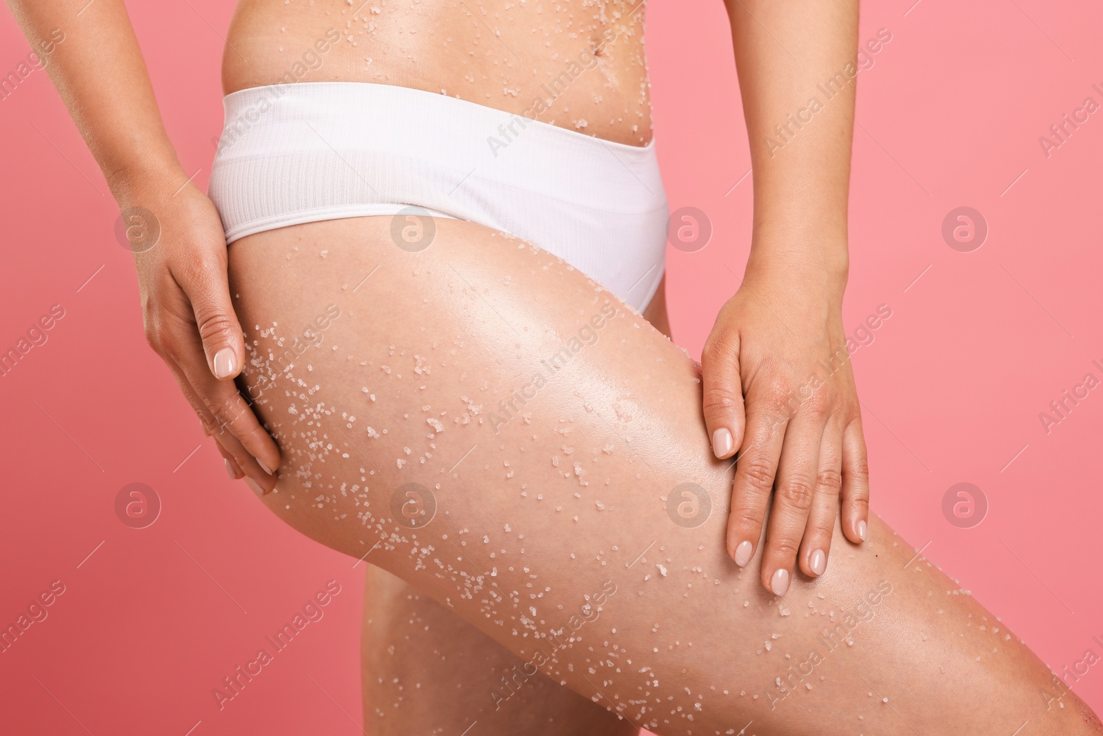 Woman with body scrub on her skin against pink background, closeup Photo of Woman with body scrub on her skin against pink background, closeup
