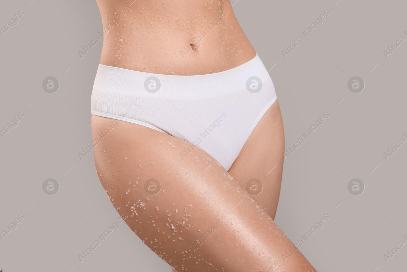 Woman with body scrub on her skin against grey background, closeup Photo of Woman with body scrub on her skin against grey background, closeup