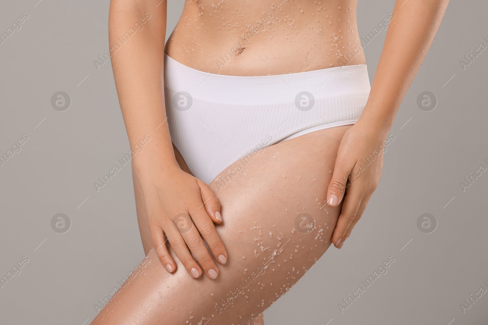 Woman with body scrub on her skin against grey background, closeup Photo of Woman with body scrub on her skin against grey background, closeup