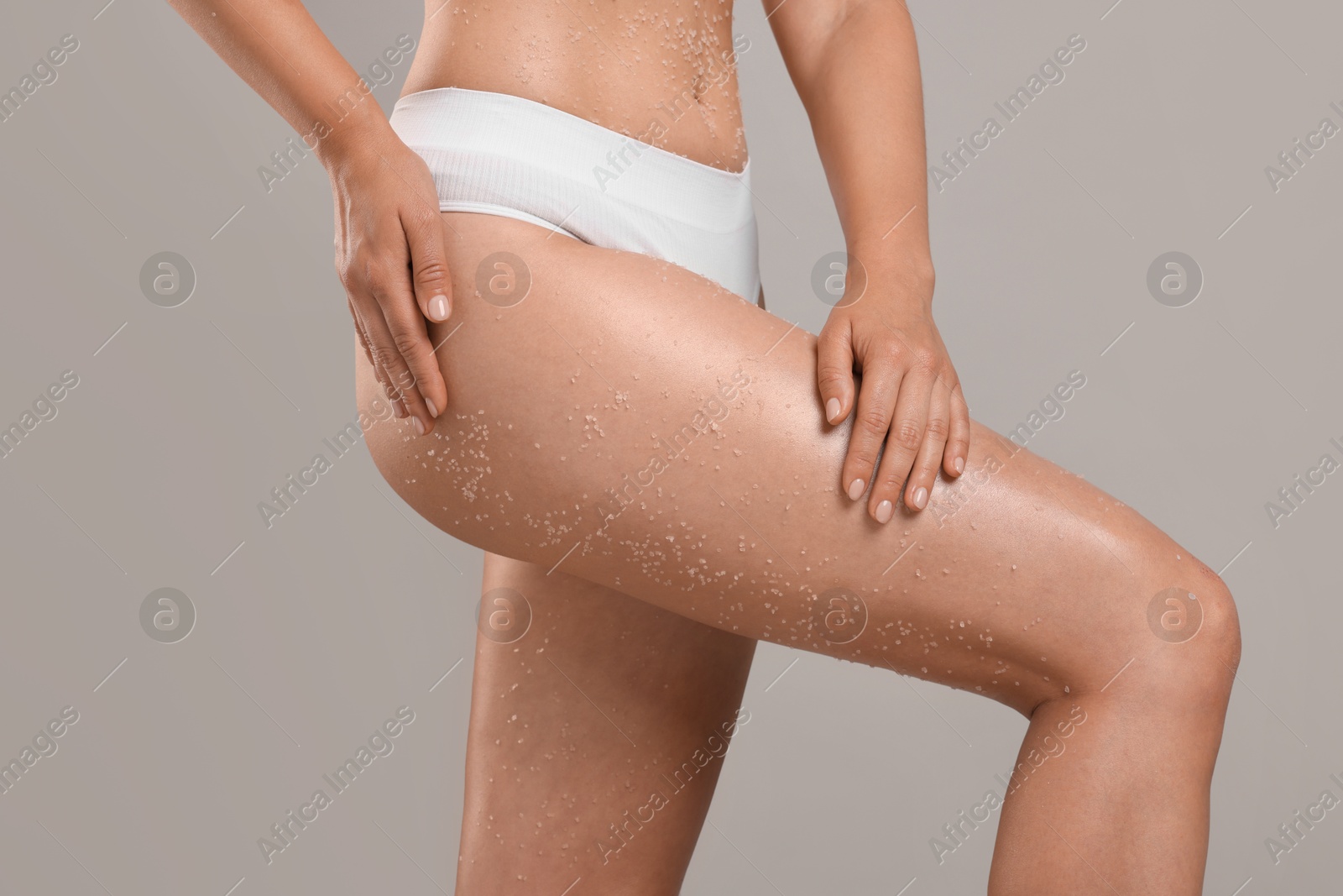 Woman with body scrub on her skin against grey background, closeup Photo of Woman with body scrub on her skin against grey background, closeup