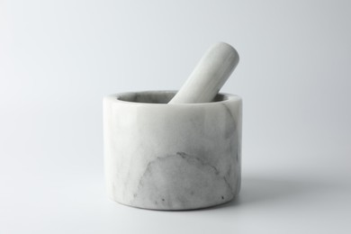 Photo of Marble mortar with pestle on white background, closeup