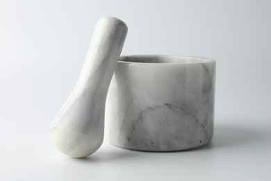 Photo of Marble mortar with pestle on white background, closeup