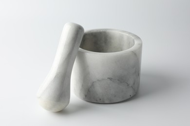 Photo of Marble mortar with pestle on white background, closeup