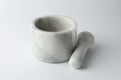 Photo of Marble mortar with pestle on white background, closeup