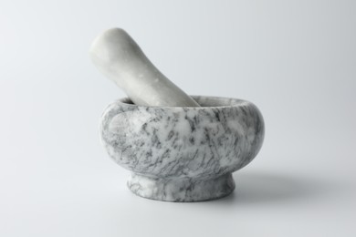 Photo of Marble mortar with pestle on white background