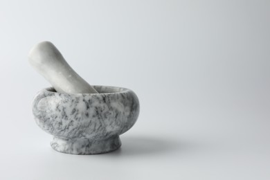 Photo of Marble mortar with pestle on white background, space for text