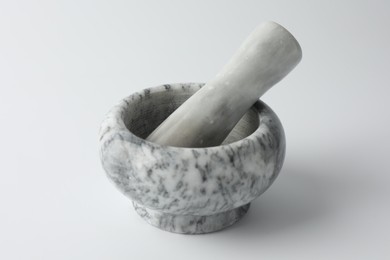 Photo of Marble mortar with pestle on white background, closeup