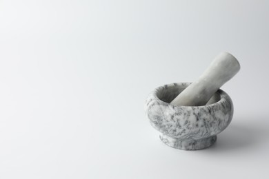 Photo of Marble mortar with pestle on white background, space for text