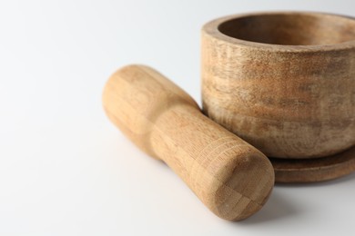 Photo of Wooden mortar with pestle on white background, closeup. Space for text