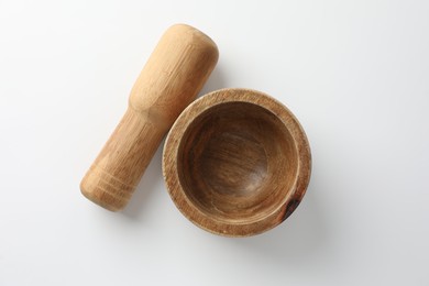 Photo of Wooden mortar with pestle on white background, flat lay