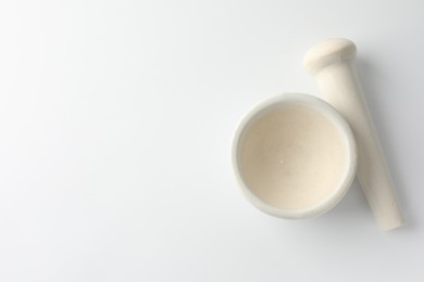 Photo of Ceramic mortar with pestle on white background, flat lay. Space for text