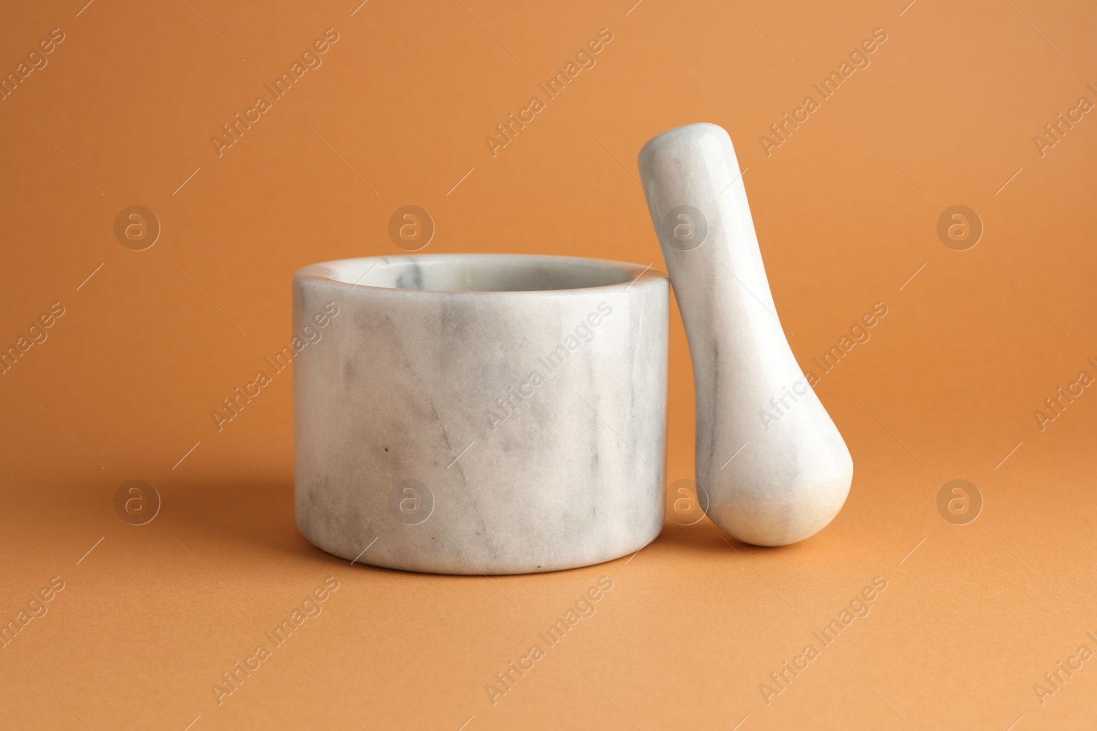 Marble mortar and pestle on light brown background, closeup Photo of Marble mortar and pestle on light brown background, closeup