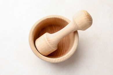 Photo of Wooden mortar and pestle on white table, top view