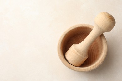 Photo of Wooden mortar and pestle on white table, top view. Space for text