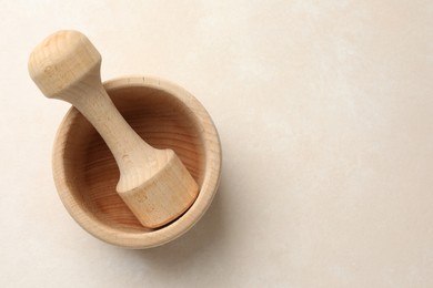 Photo of Wooden mortar and pestle on white table, top view. Space for text