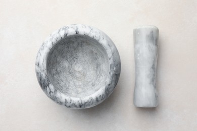 Photo of Marble mortar and pestle on white table, top view