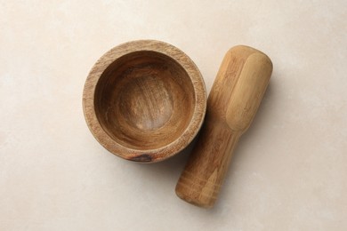 Photo of Wooden mortar and pestle on white table, top view