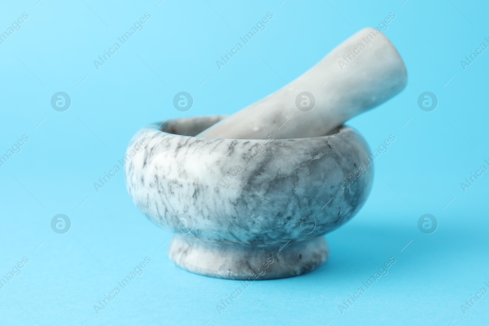 Marble mortar and pestle on light blue background, closeup Photo of Marble mortar and pestle on light blue background, closeup
