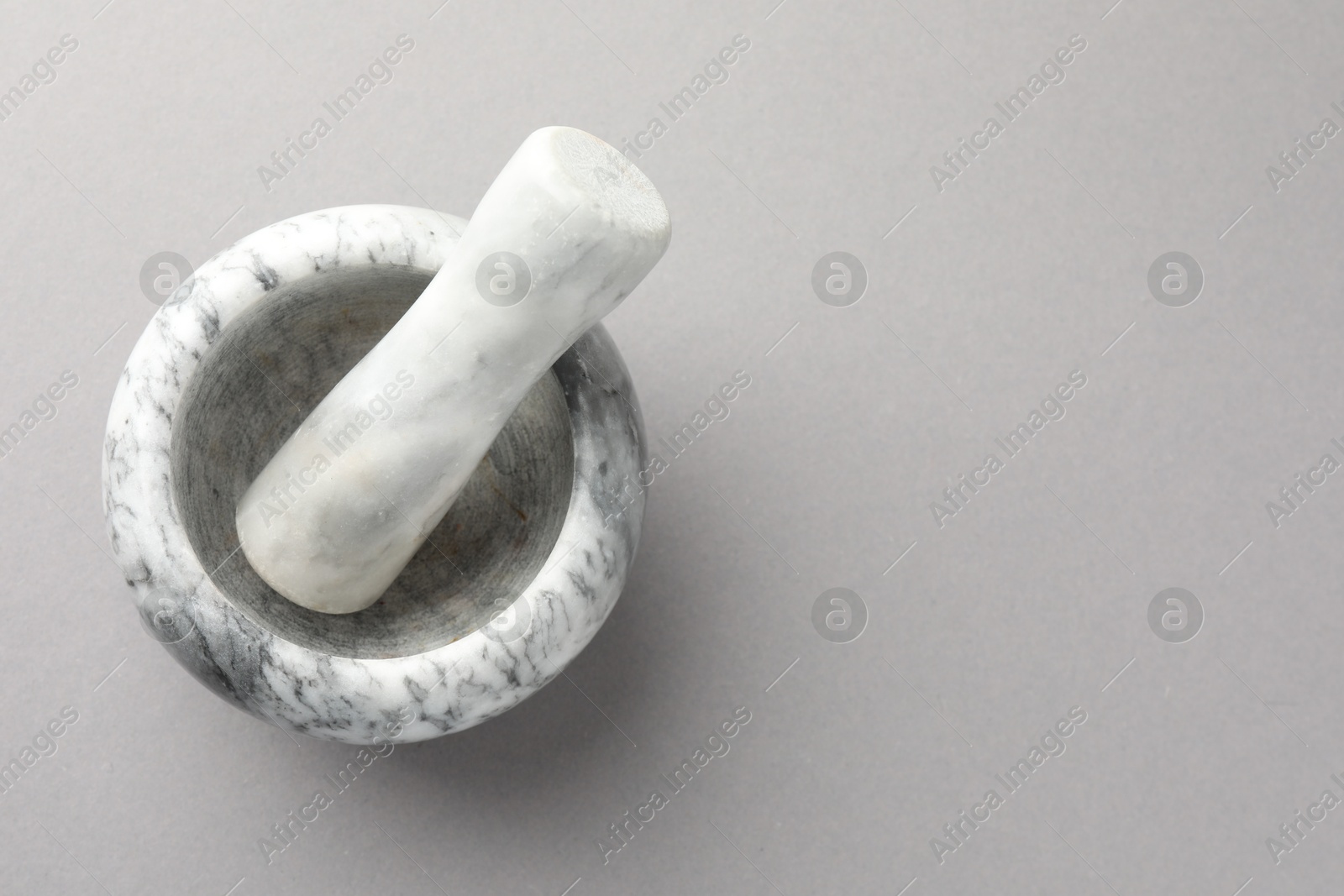 Marble mortar and pestle on light grey background, top view. Space for text Photo of Marble mortar and pestle on light grey background, top view. Space for text