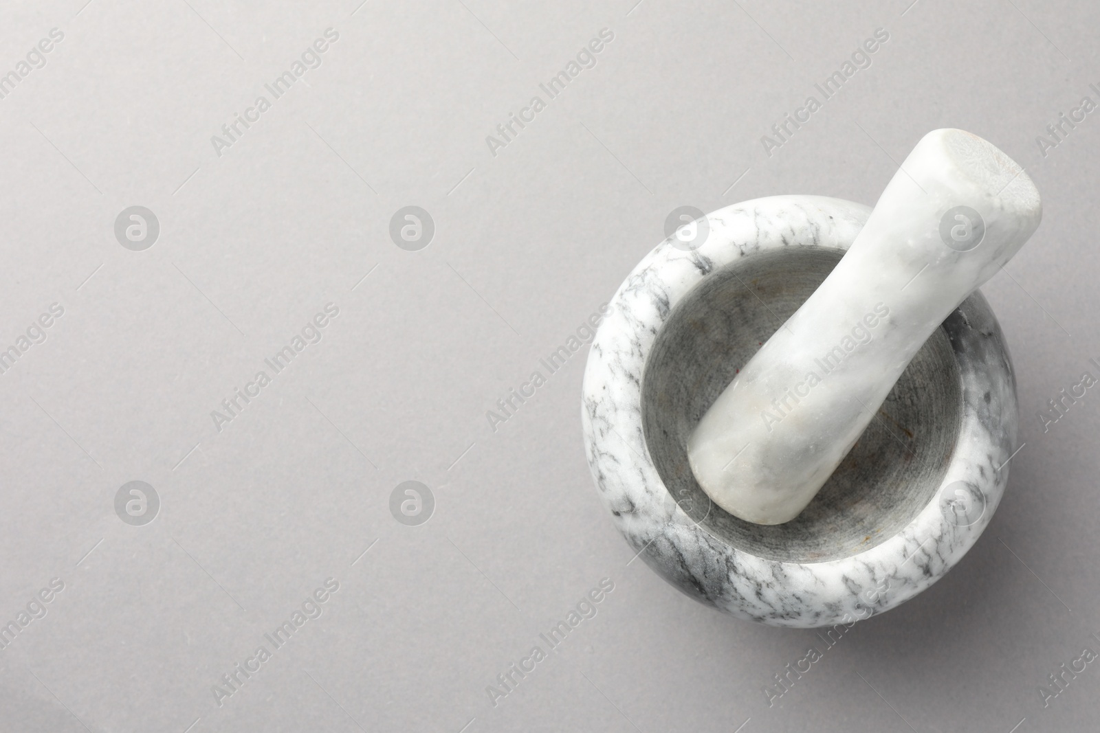 Marble mortar and pestle on light grey background, top view. Space for text Photo of Marble mortar and pestle on light grey background, top view. Space for text