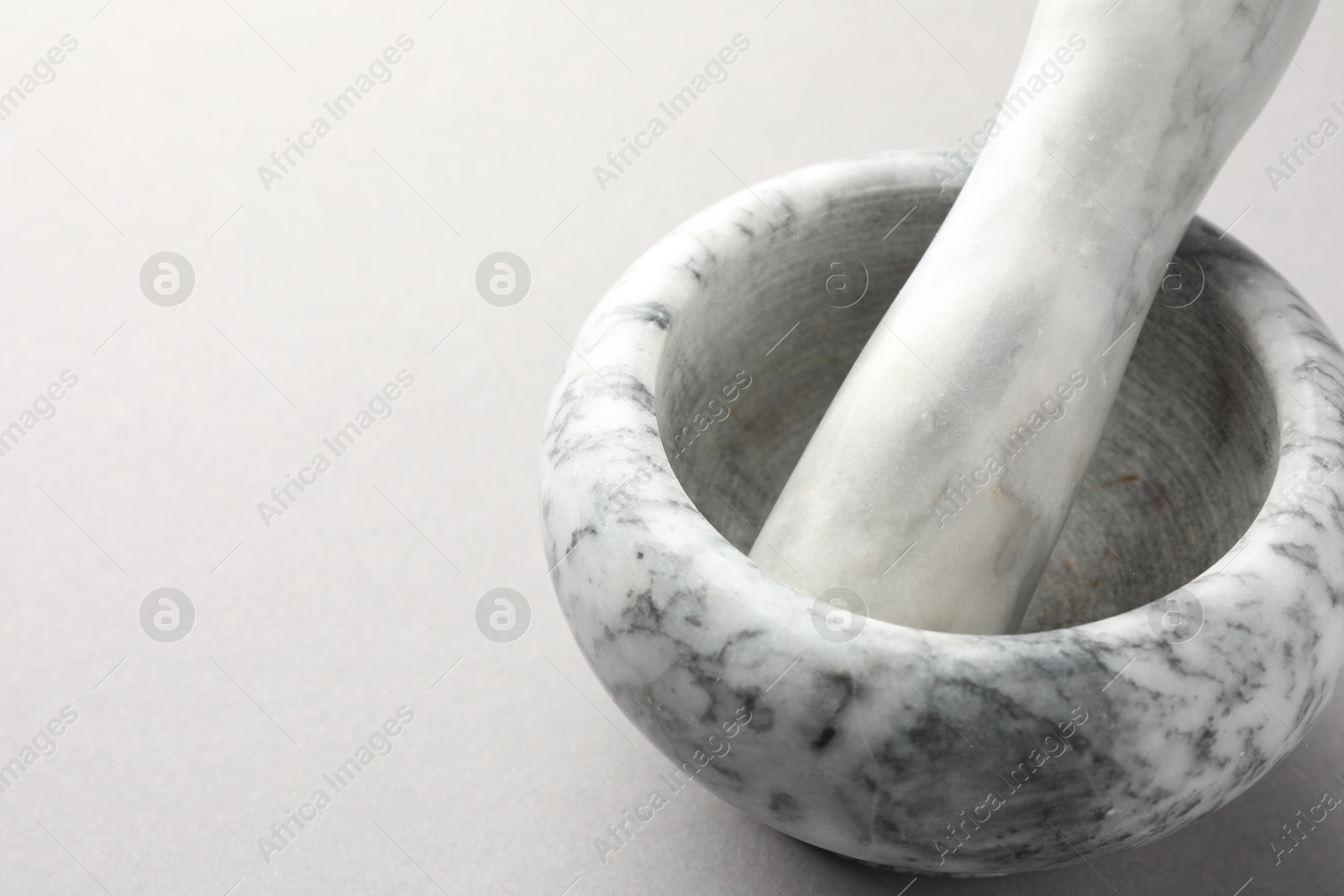 Marble mortar and pestle on light grey background, closeup. Space for text Photo of Marble mortar and pestle on light grey background, closeup. Space for text