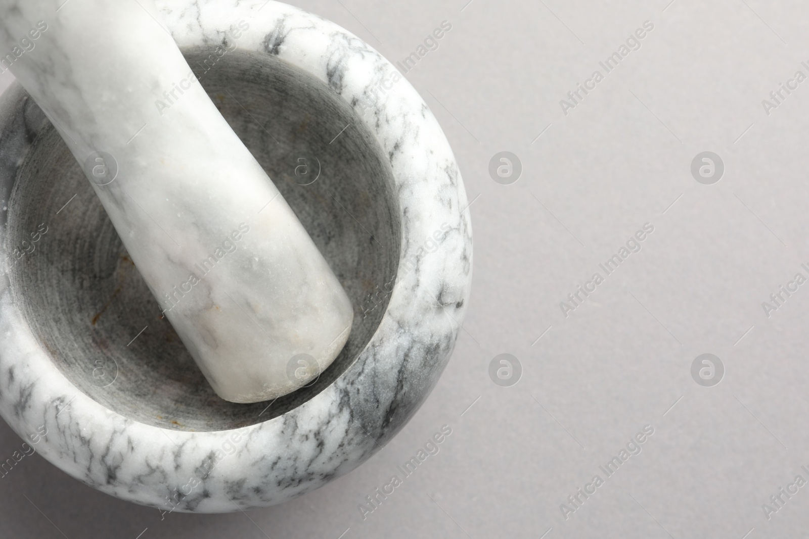 Marble mortar and pestle on light grey background, top view. Space for text Photo of Marble mortar and pestle on light grey background, top view. Space for text