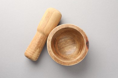 Photo of Wooden mortar and pestle on light grey background, top view
