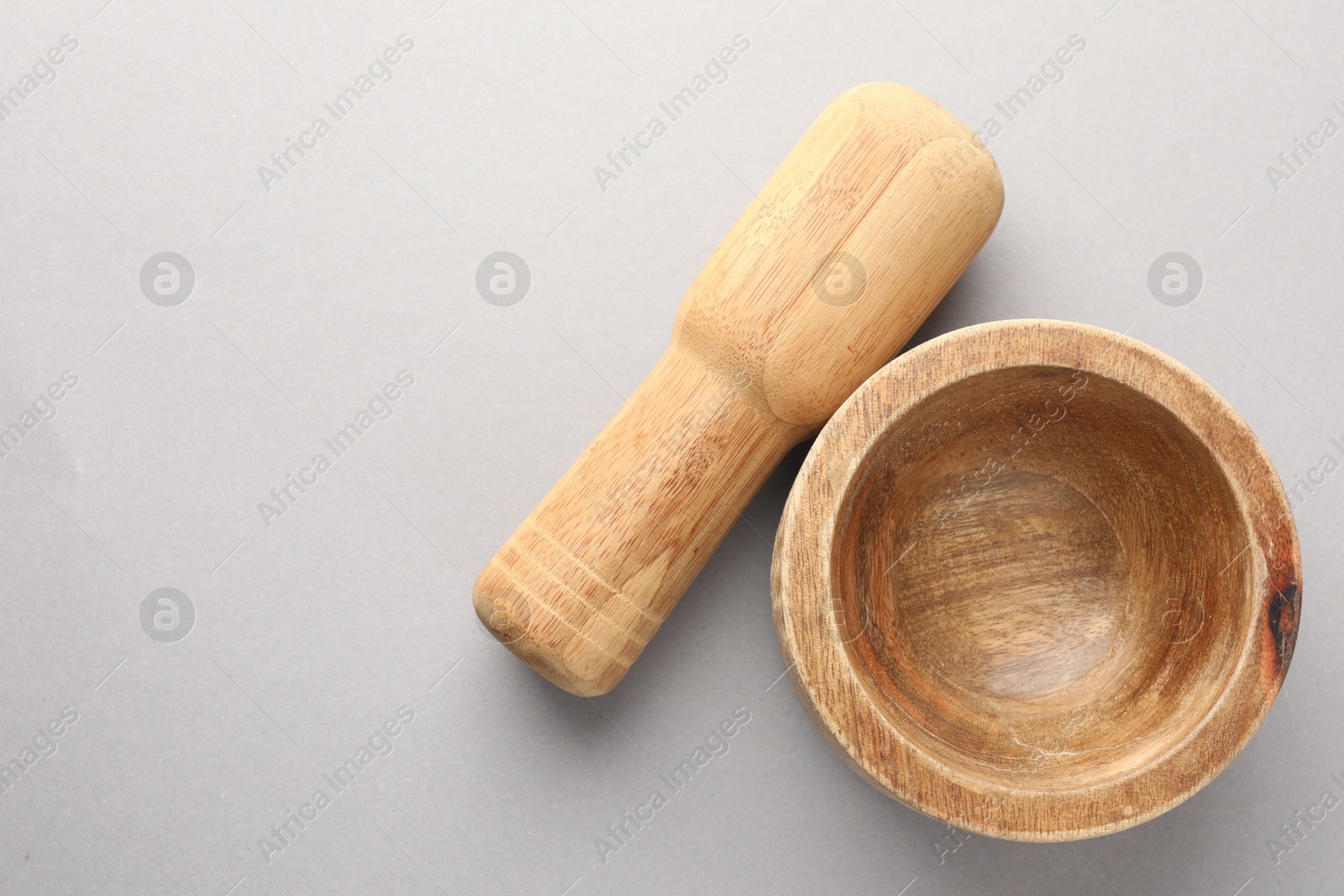 Wooden mortar and pestle on light grey background, top view. Space for text Photo of Wooden mortar and pestle on light grey background, top view. Space for text