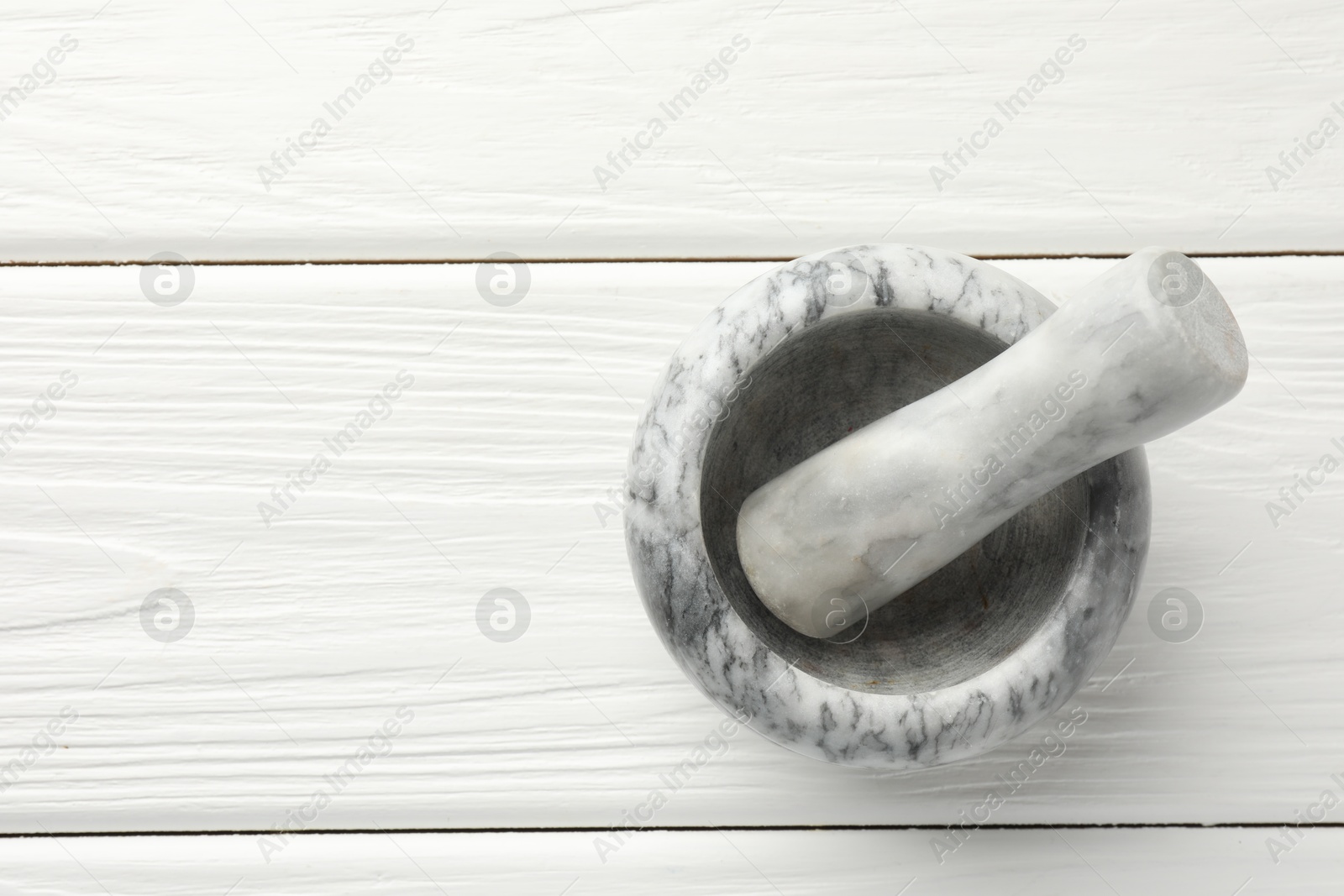 Marble mortar and pestle on white wooden table, top view. Space for text Photo of Marble mortar and pestle on white wooden table, top view. Space for text