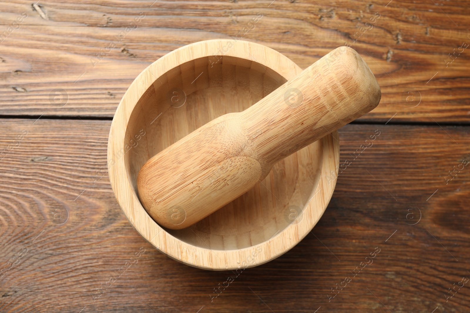 Mortar and pestle on wooden table, top view Photo of Mortar and pestle on wooden table, top view