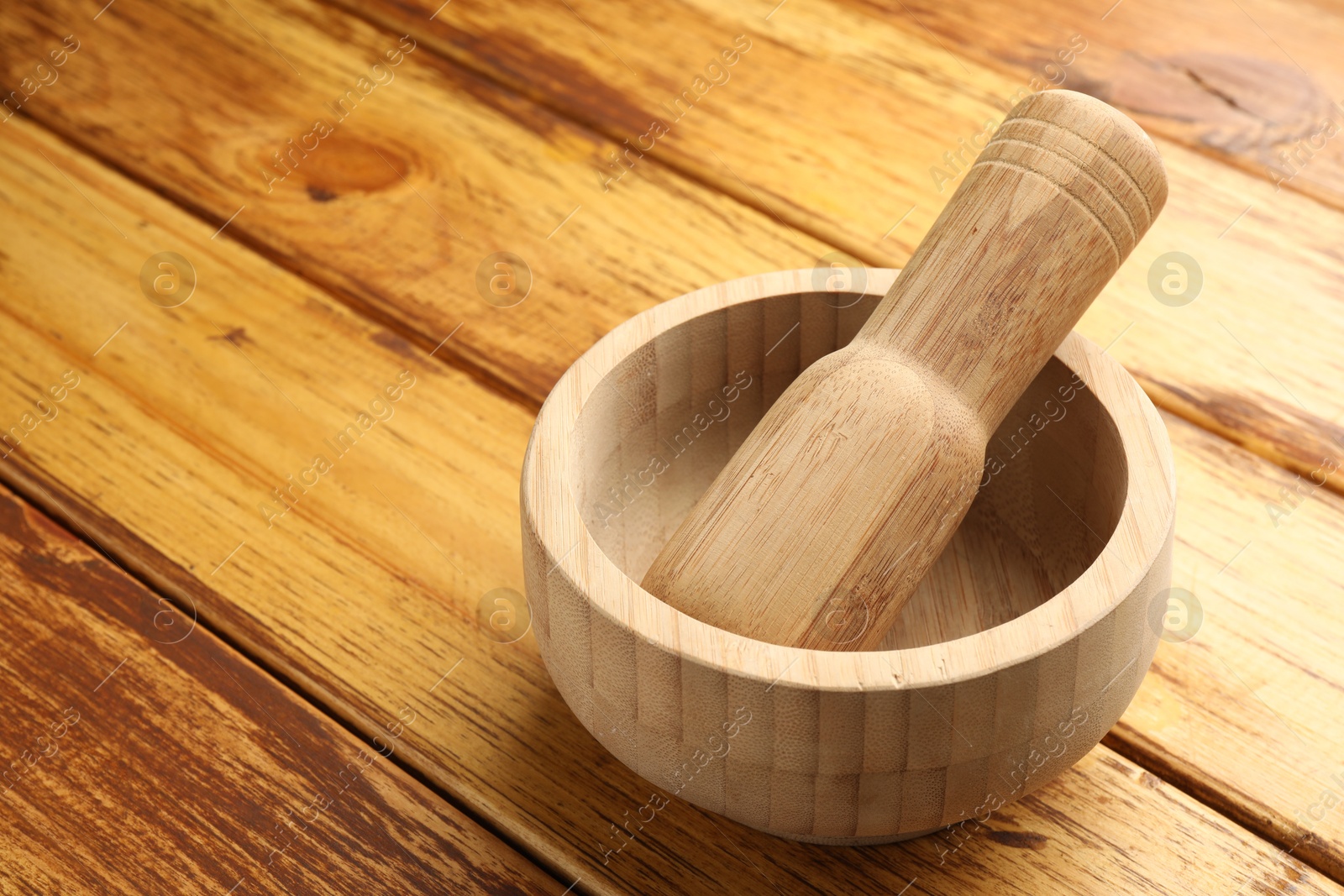Mortar and pestle on wooden table, closeup. Space for text Photo of Mortar and pestle on wooden table, closeup. Space for text