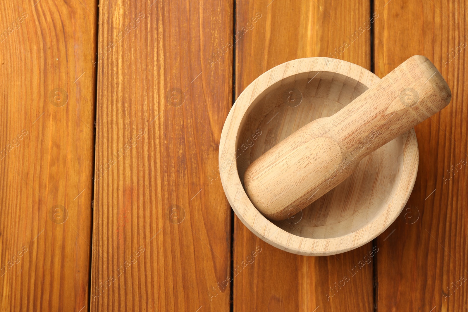 Mortar and pestle on wooden table, top view. Space for text Photo of Mortar and pestle on wooden table, top view. Space for text