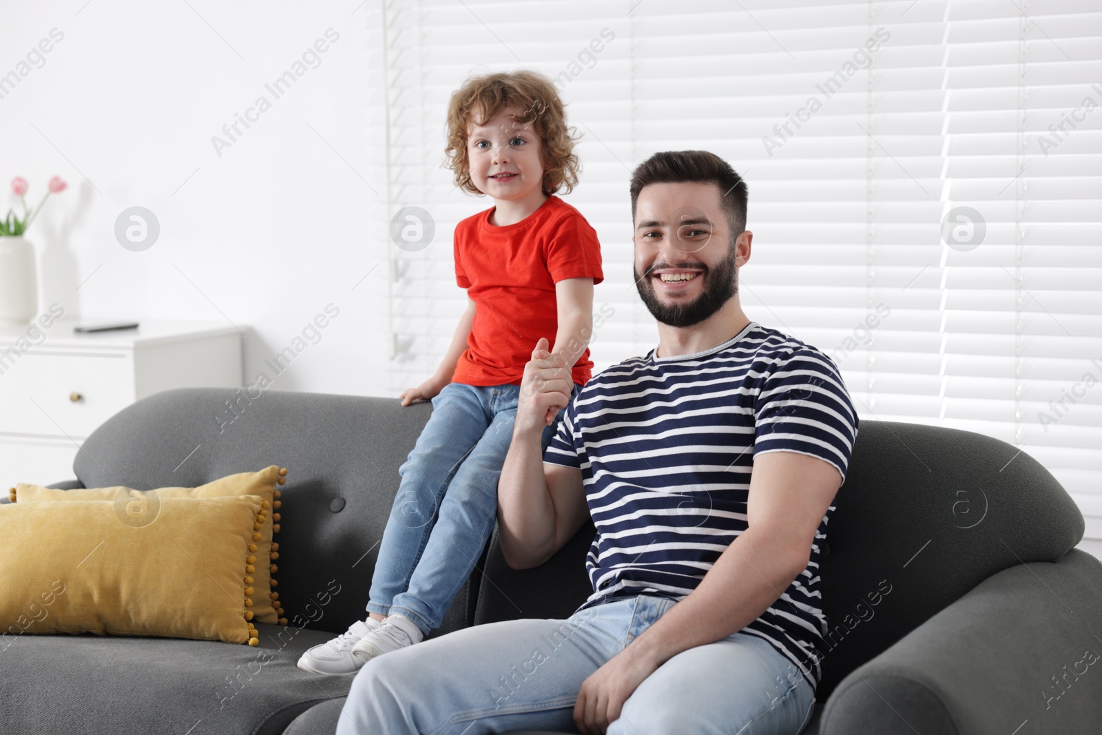 Happy father and his son spending time together on sofa at home Photo of Happy father and his son spending time together on sofa at home
