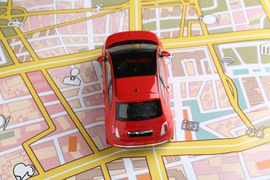 Photo of Road trip concept. Toy car on city map, above view
