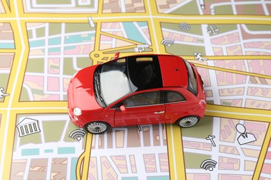 Photo of Road trip concept. Toy car on city map, above view
