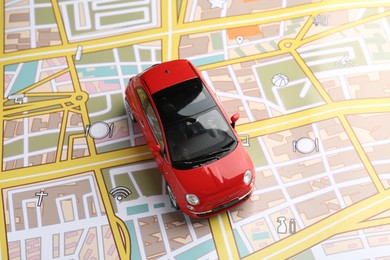 Photo of Road trip concept. Toy car on city map, above view