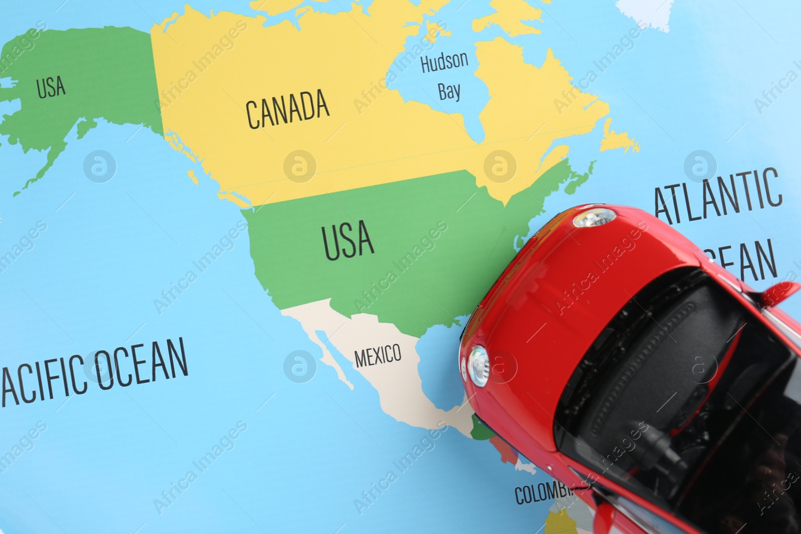 Road trip concept. Toy car on world map, top view Photo of Road trip concept. Toy car on world map, top view
