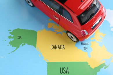 Photo of Road trip concept. Toy car on world map, above view