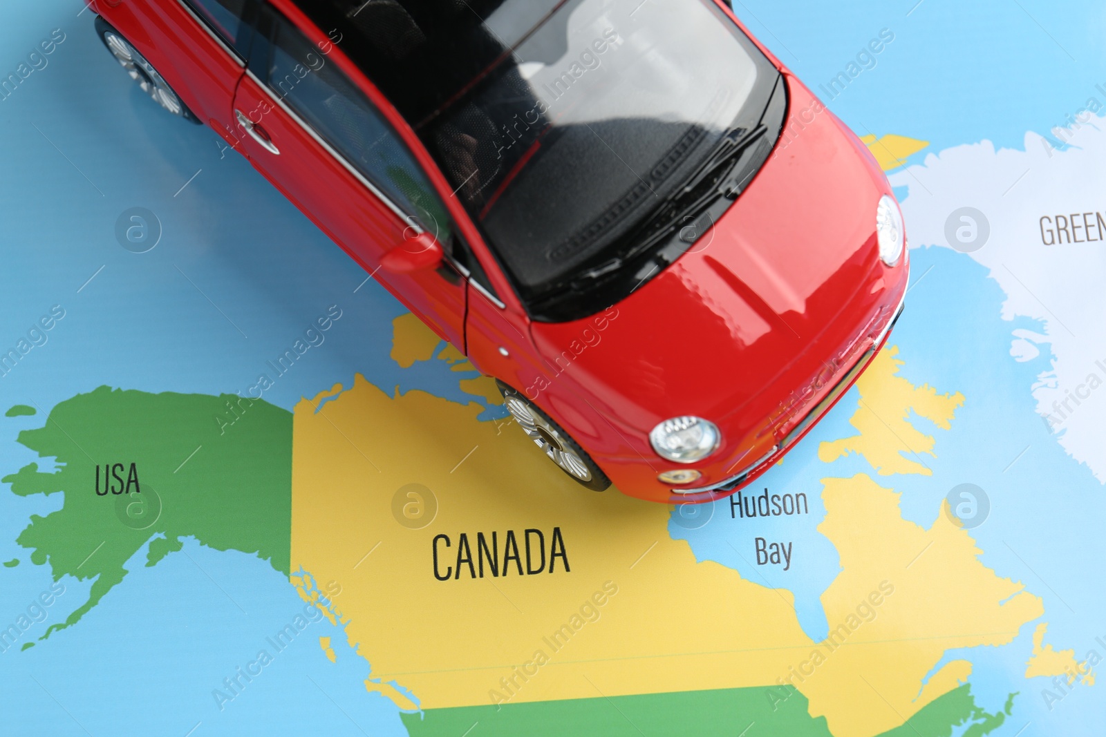 Road trip concept. Toy car on world map, above view Photo of Road trip concept. Toy car on world map, above view