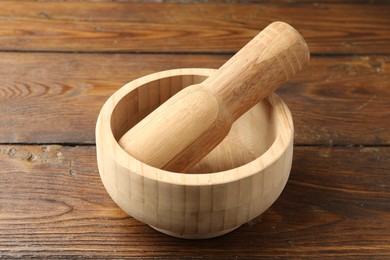 Photo of Mortar and pestle on wooden table, closeup